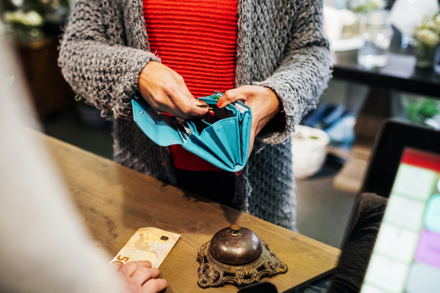 A woman paying for some flowers at the cash register at her local florist.