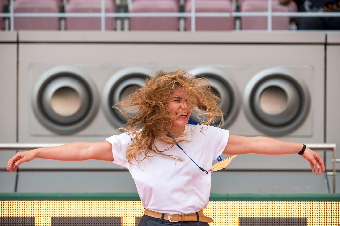 A woman stands in front of air-conditioning vents