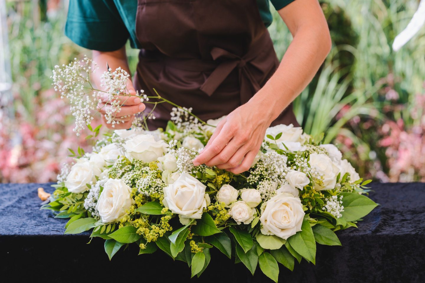 Gardener woman creating a grave floral piece