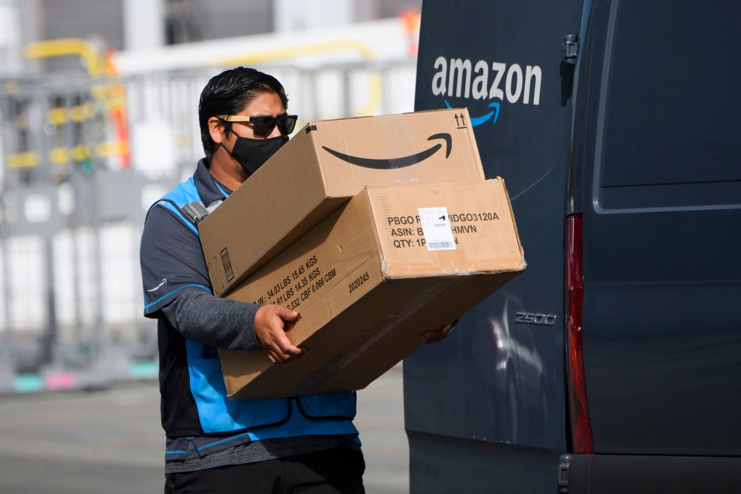 An Amazon delivery drivers carries packages