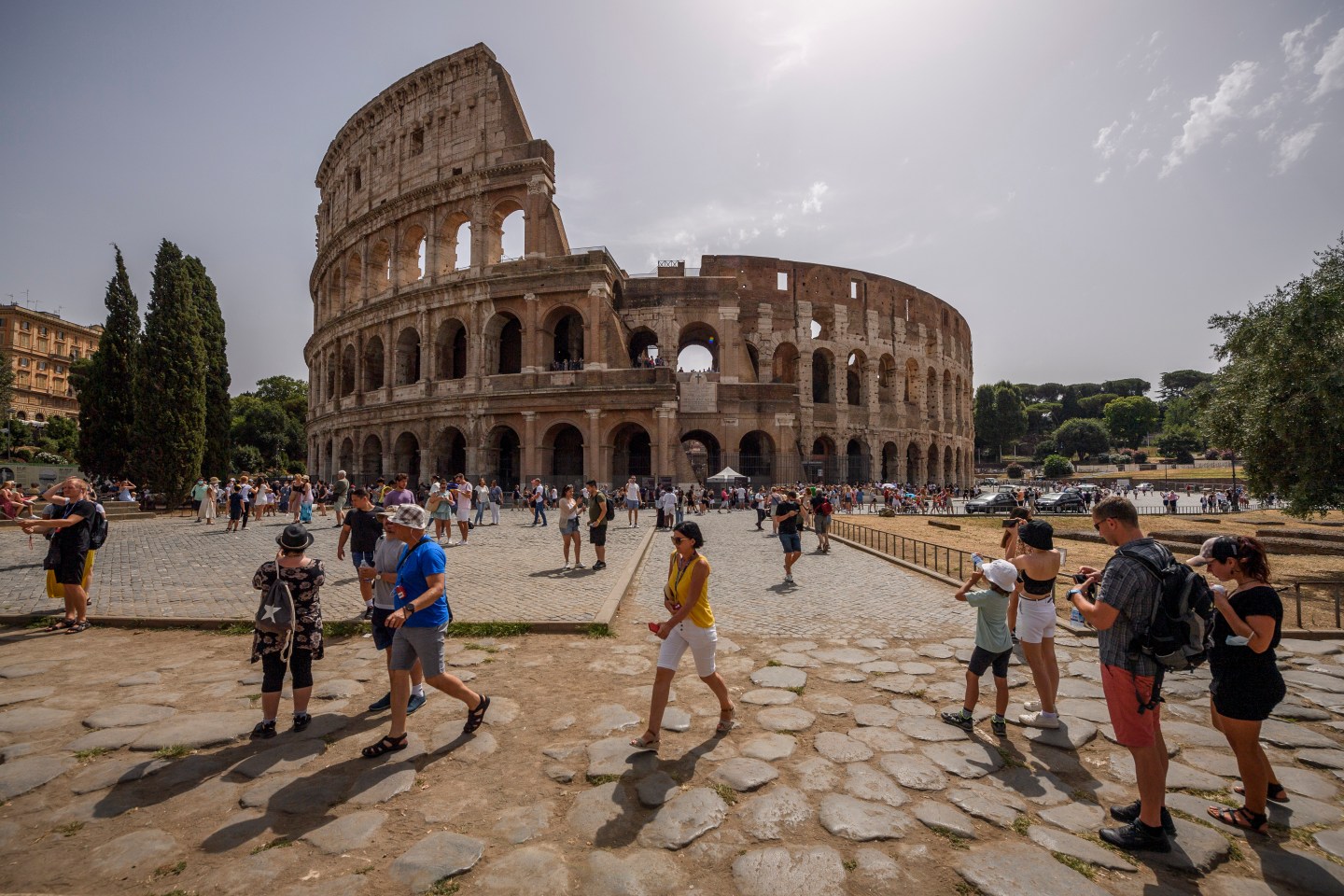 Tourists walking around Rome in front of the Colosseum