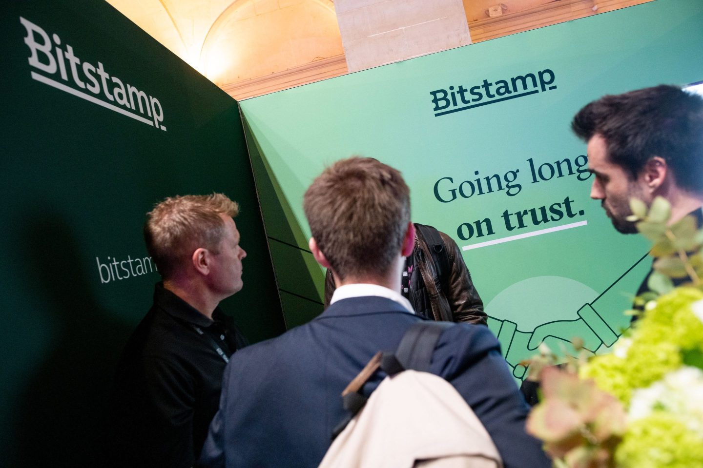 People talking at the Bitstamp Ltd. booth at the Blockchain Week Summit