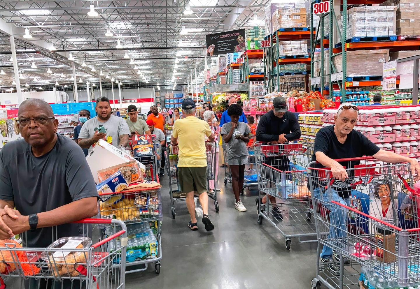 Shoppers wait in a check-out line at a Costco wholesale