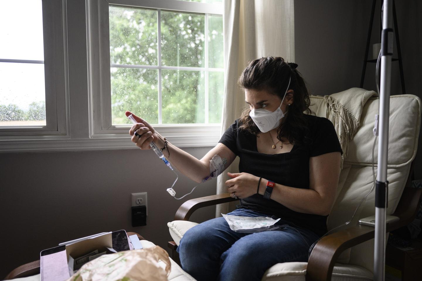 A disabled former nurse giving herself a saline infusion.