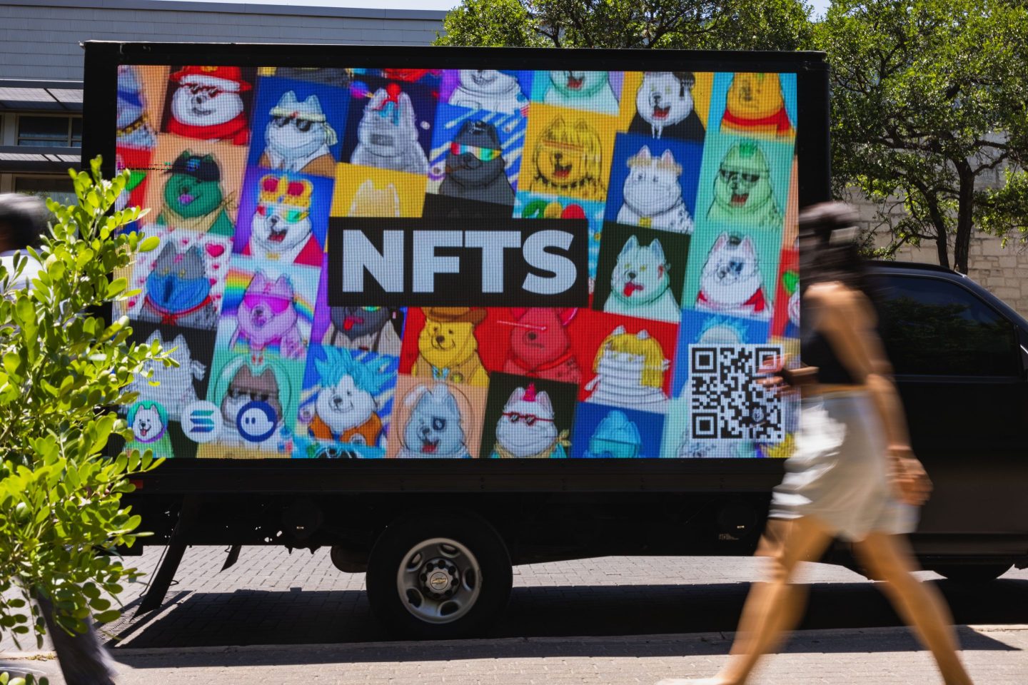 Photo of someone walking by an NFT advertisement.