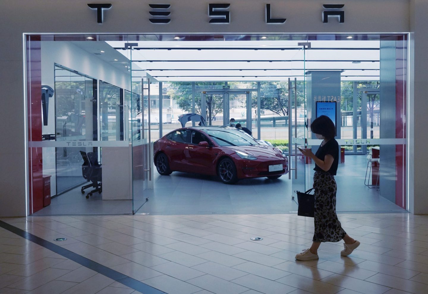 A customer walks past a Tesla sales store in Hangzhou, East China's Zhejiang Province on June 19, 2022.