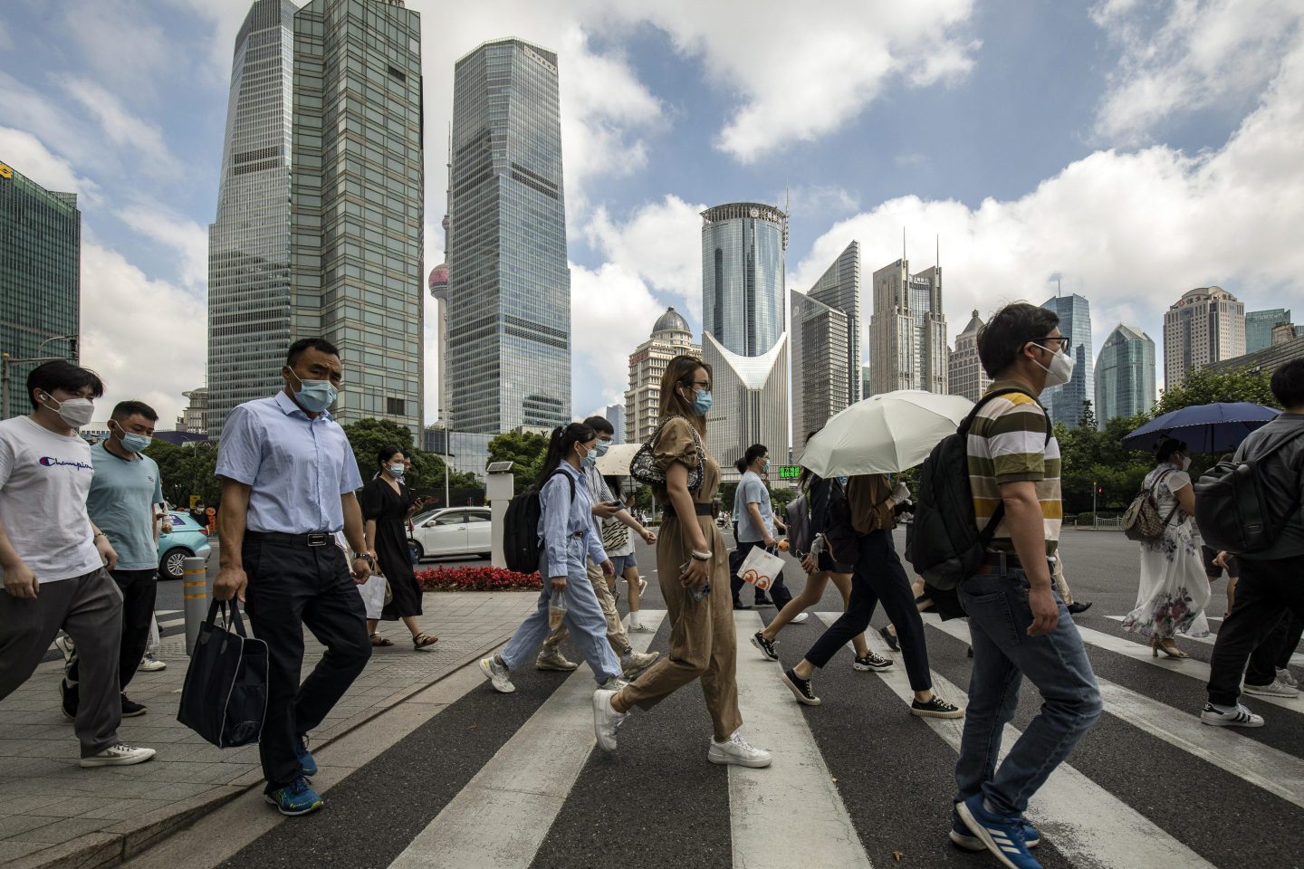 Photo of pedestrians crossing a road in Shanghai's financial district.