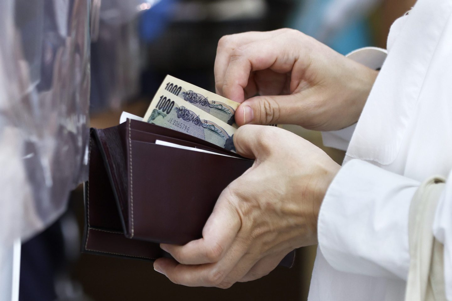 A customer prepares Japanese 1,000 yen banknotes while making a purchase at an Akidai YK supermarket in Tokyo, Japan, on Monday, June 27, 2022. Japan&#8217;s key inflation gauge stayed above the Bank of Japan&#8217;s target level of 2%, a result that will likely keep speculation alive over possible policy adjustments at the central bank. Photographer: Kiyoshi Ota/Bloomberg via Getty Images