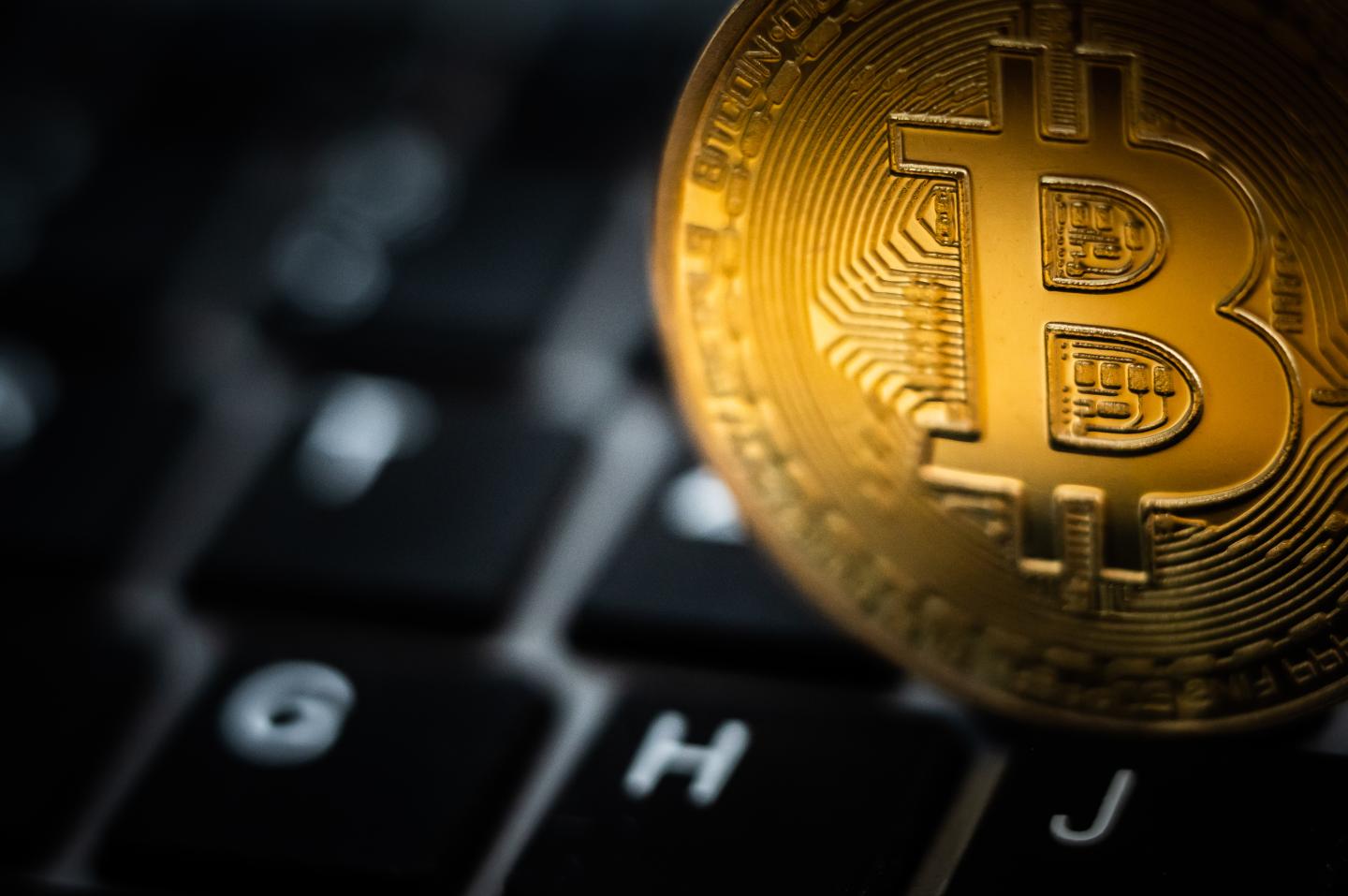 A symbolic "Bitcoin coin" is seen on a keyboard of a computer