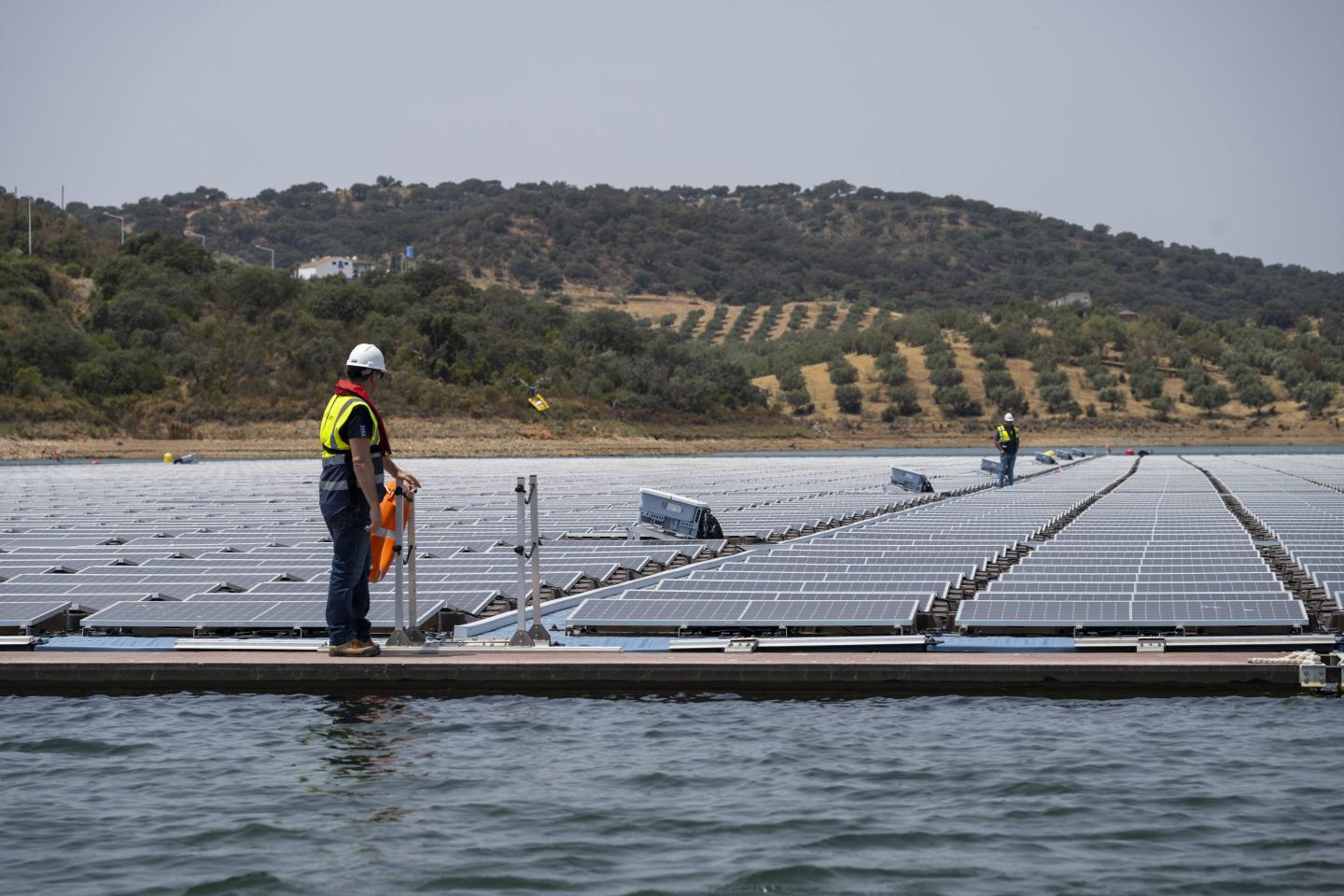 Workers at a floating solar farm in Portugal