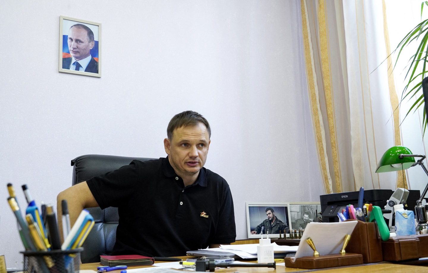 Kirill Stremousov, deputy head of the Russian-installed Kherson administration, is pictured in his office, with a portrait of Russian President Vladimir Putin seen on the wall behind him, in the city of Kherson on July 20, 2022.