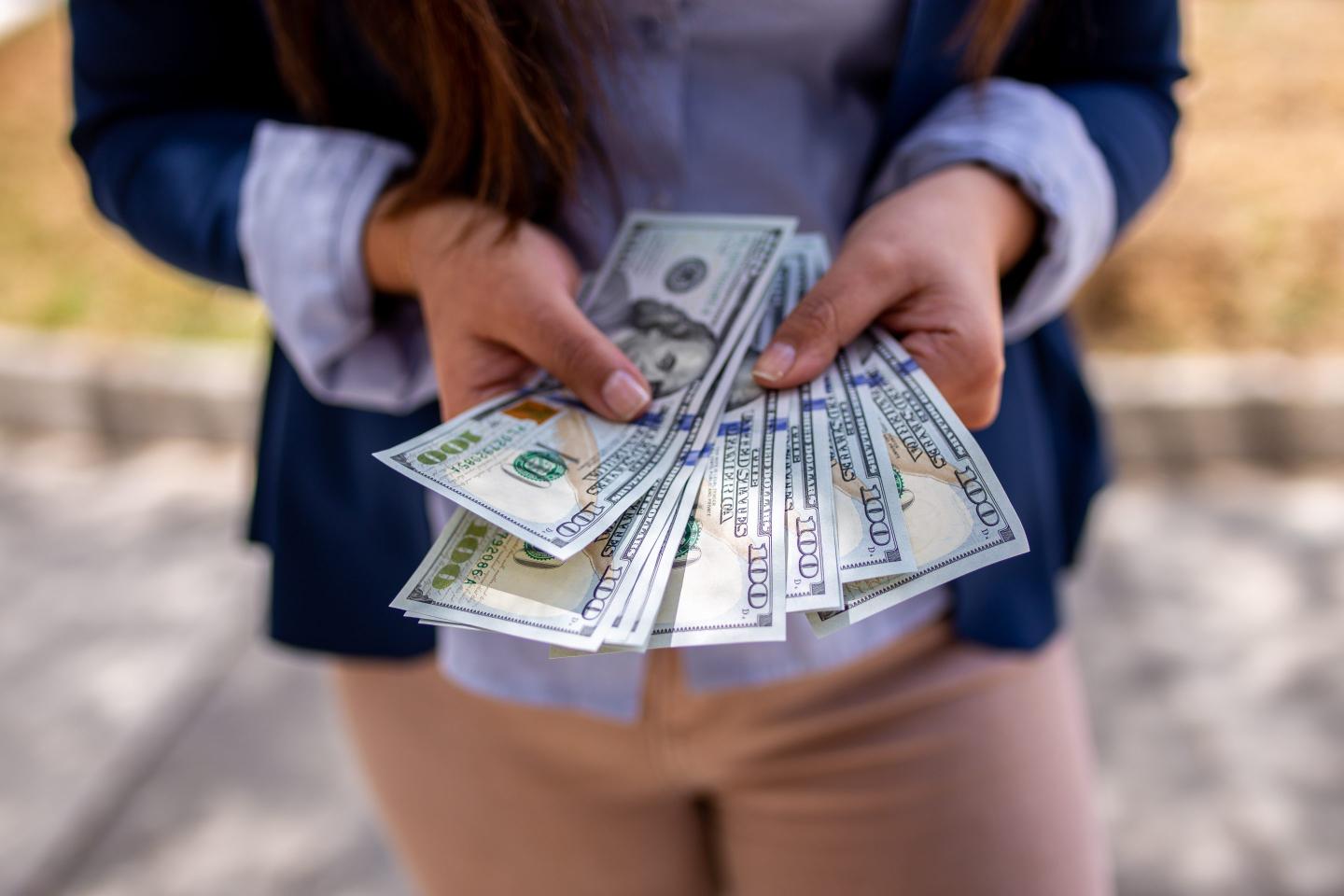 A woman holding cash.