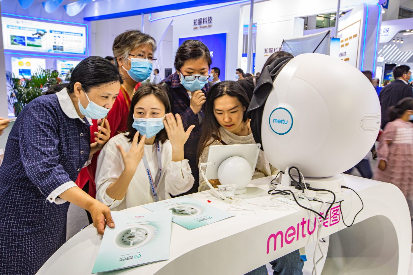 Visitors gather around a Meitu booth