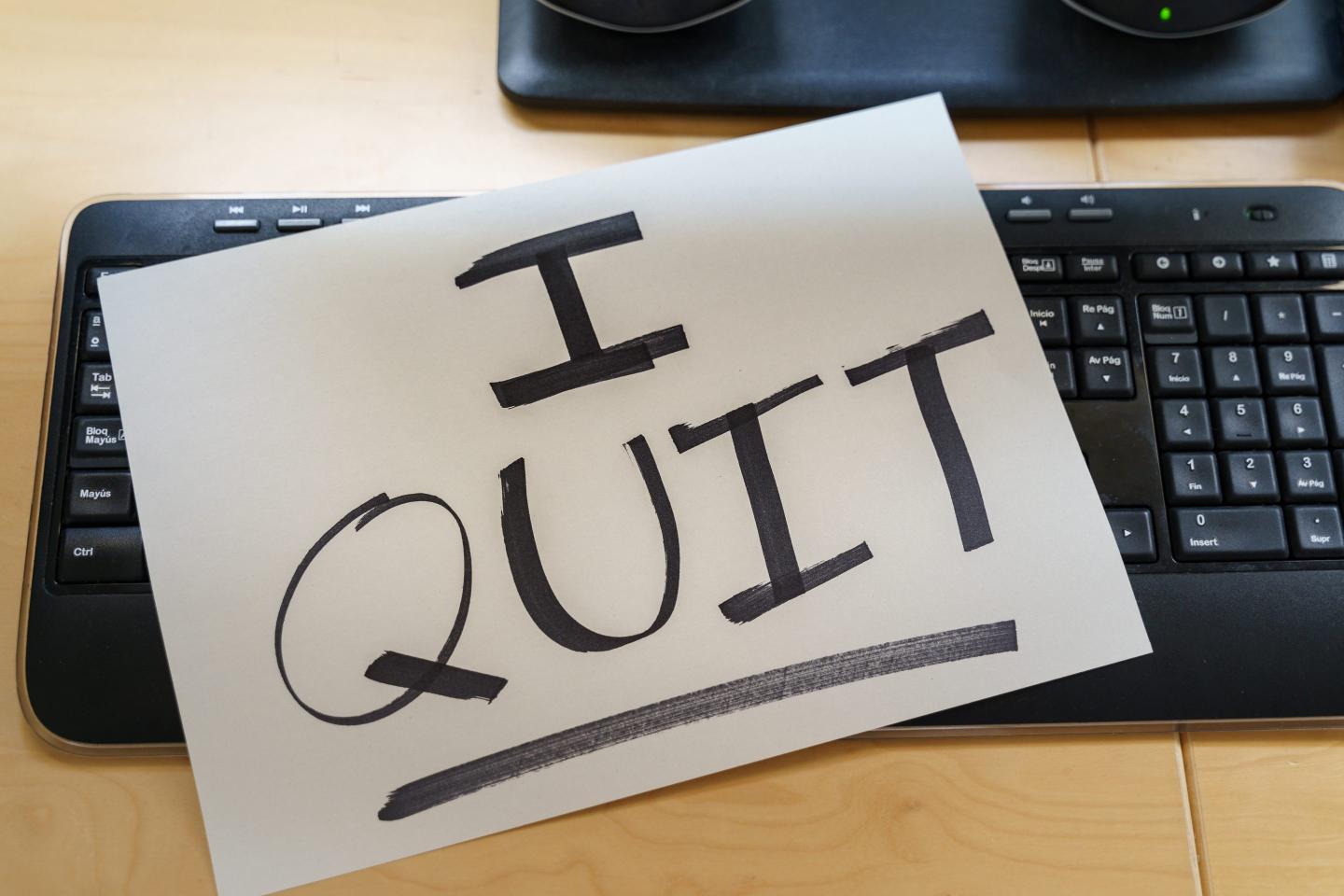 Note on a keyboard of a work computer with the text I QUIT