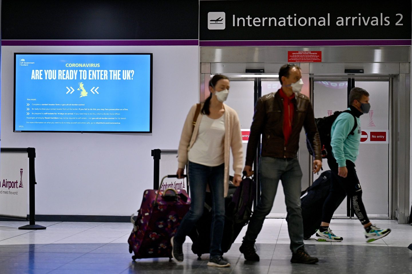 Passengers with rolling bags at Edinburgh airport.