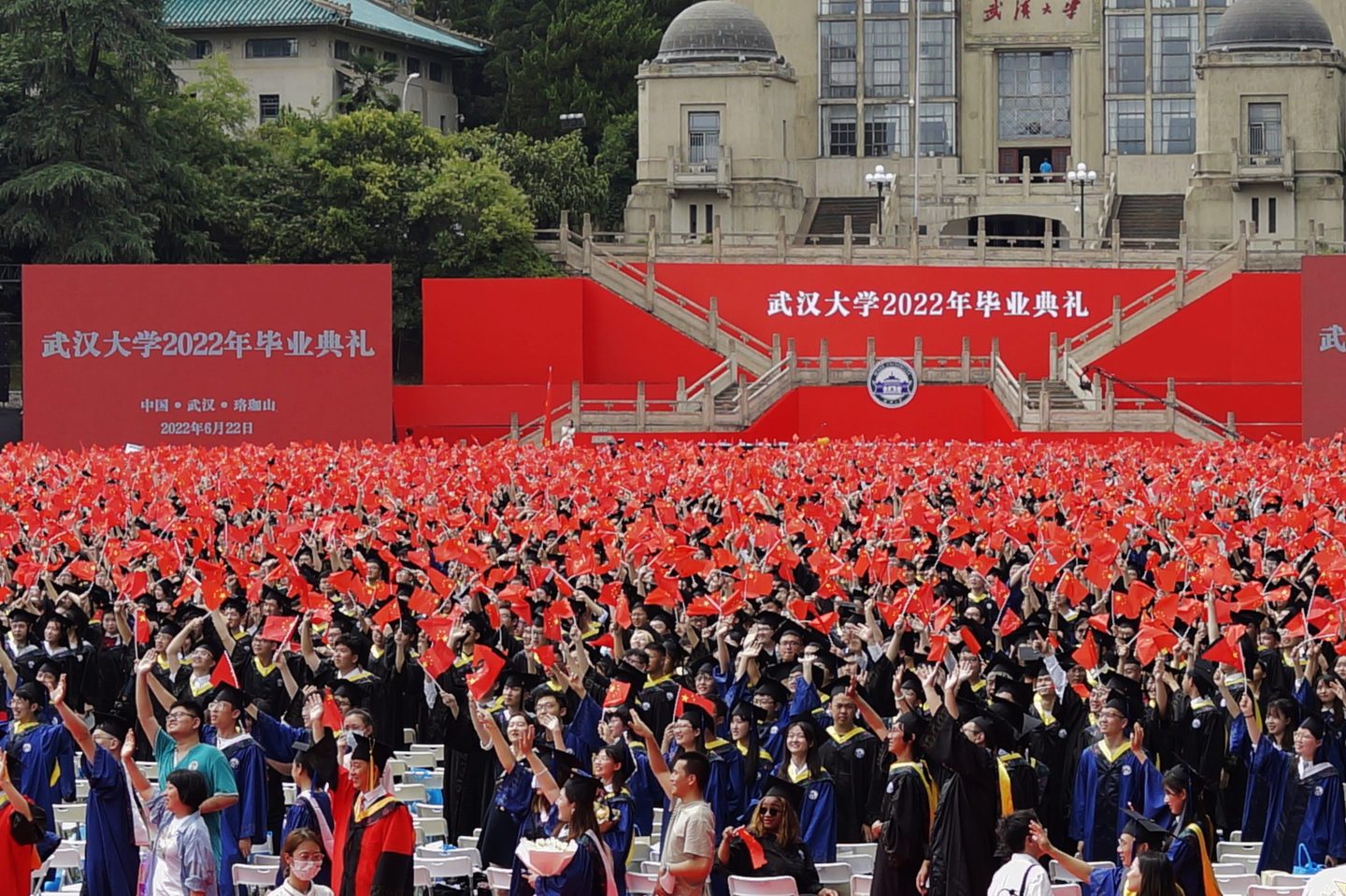 Photo of Chinese university graduates waving Chinese national flags during Wuhan University's graduation ceremony on June 22, 2022, in Wuhan, Hubei province of China.