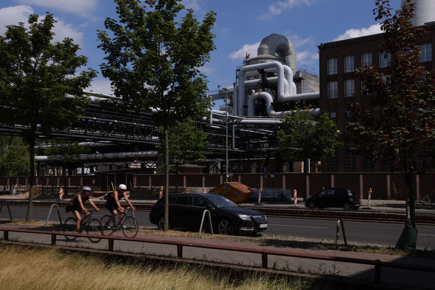Bicyclists riding in front of a natural-gas powered station in Berlin