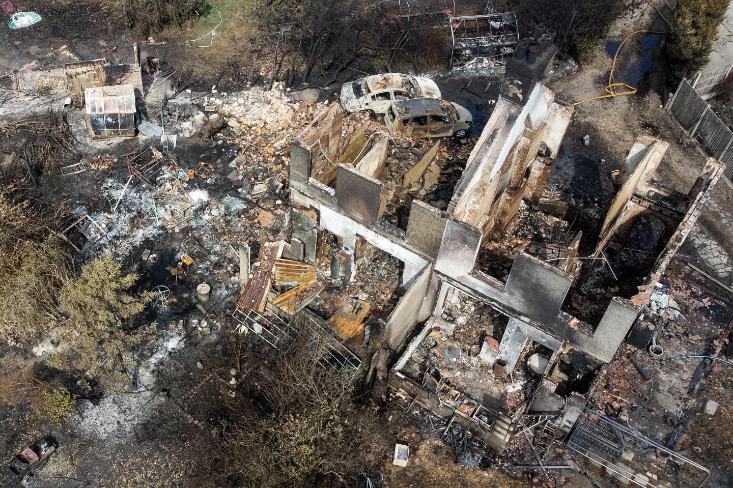 An aerial view shows the rubble and destruction in a residential area following a large blaze the previous day, on July 20, 2022 in Wennington, Greater London.