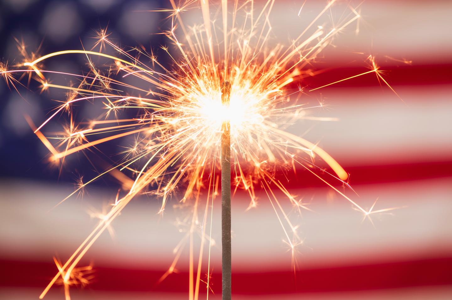 A sparkler in front of the American flag.