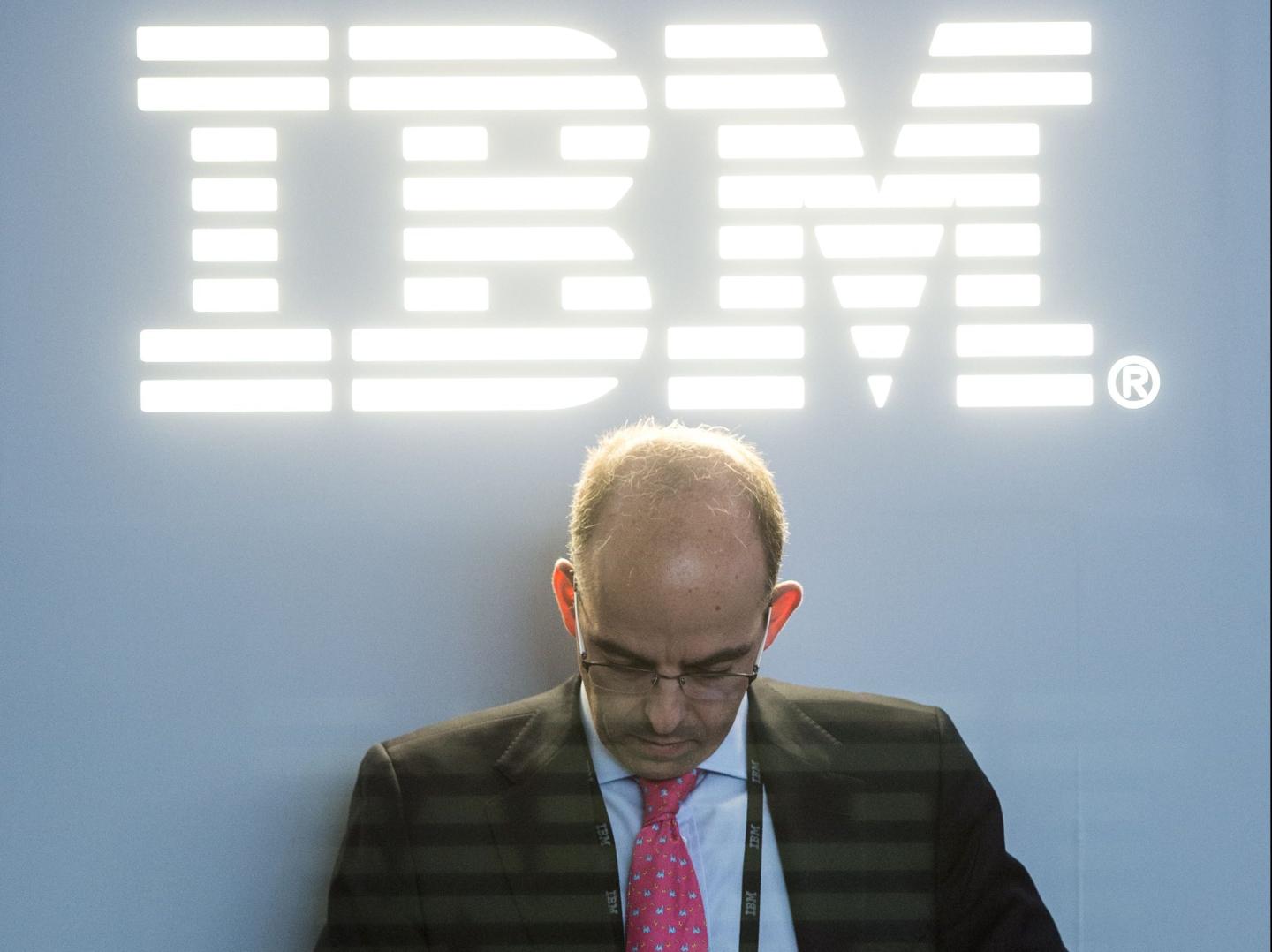 A man stands under IBM logo