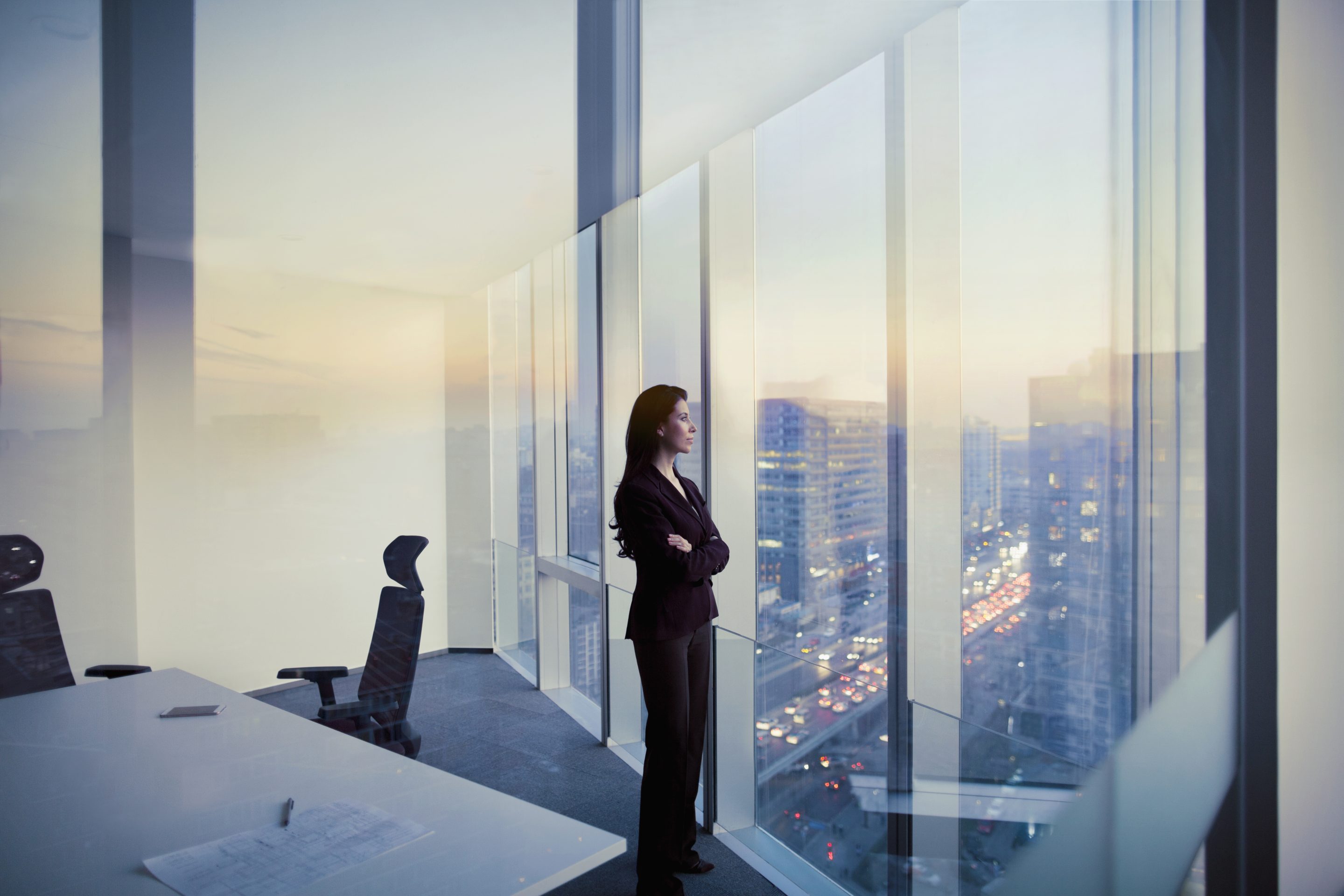 Adult Hispanic woman CEO executive businesswoman business person in conference meeting room in contemporary modern office daylight sunset dusk talking planning thinking strategy well dressed suit diversity multi-ethnic problems solutions unity cityscape downtown urban new beginnings breaking new ground decisions choices the way forward contemplation vision focus choices decisions solitude quiet alone