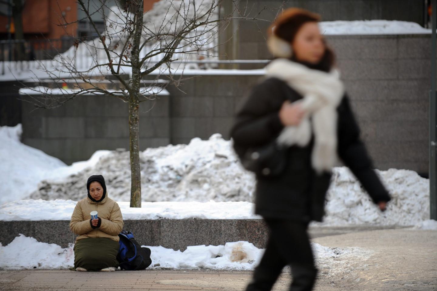 An homeless old lady begs for money in t