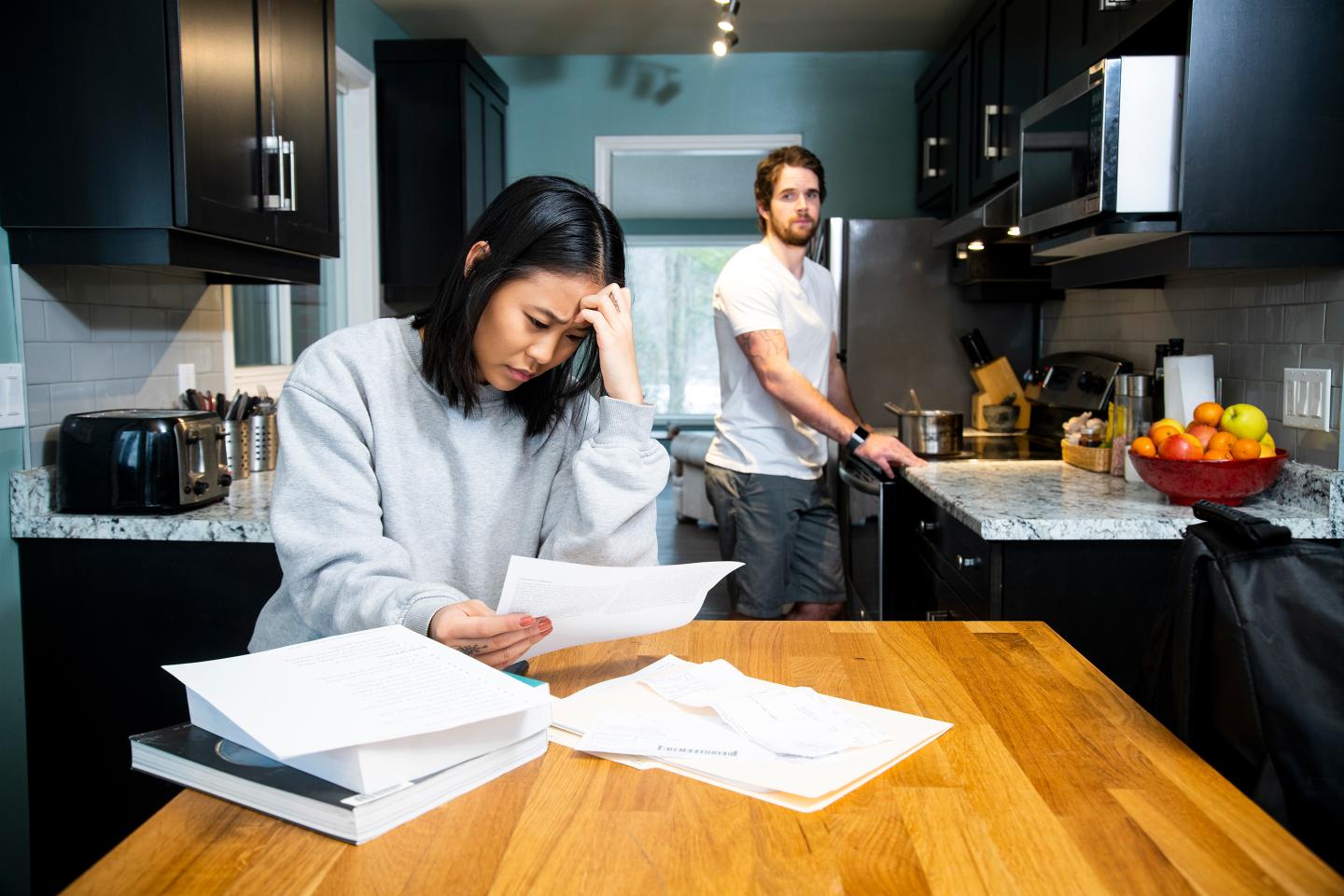 Millennial couple looking at bills at home.