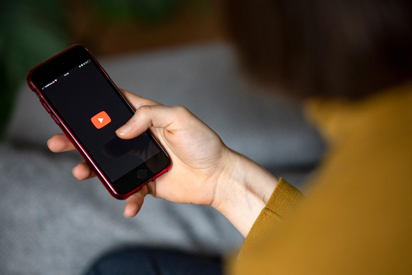Woman holding phone with youtube