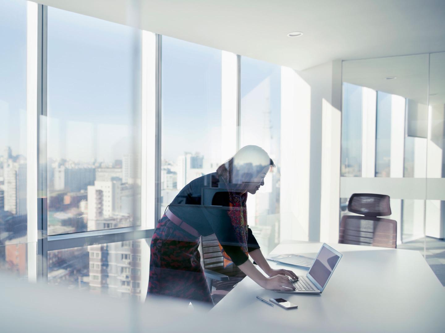 Female CEO standing at window at desk