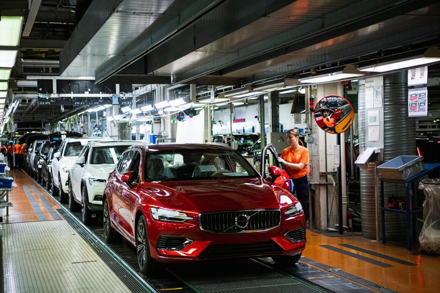 Workers inspect finished cars on Volvo's production line in Gothenburg, Sweden.