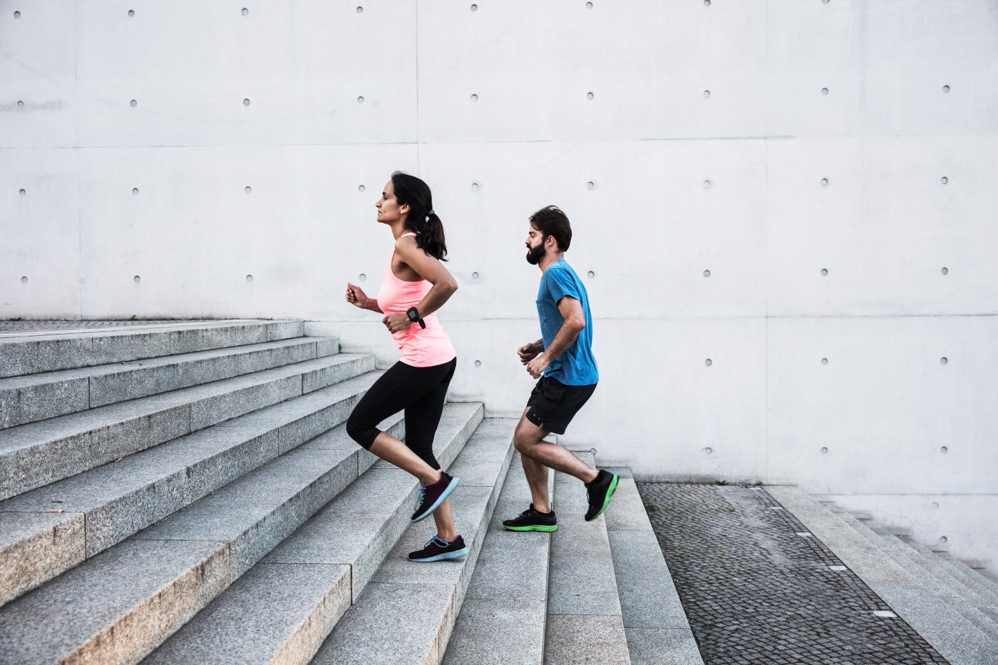 a woman and man running up stairs
