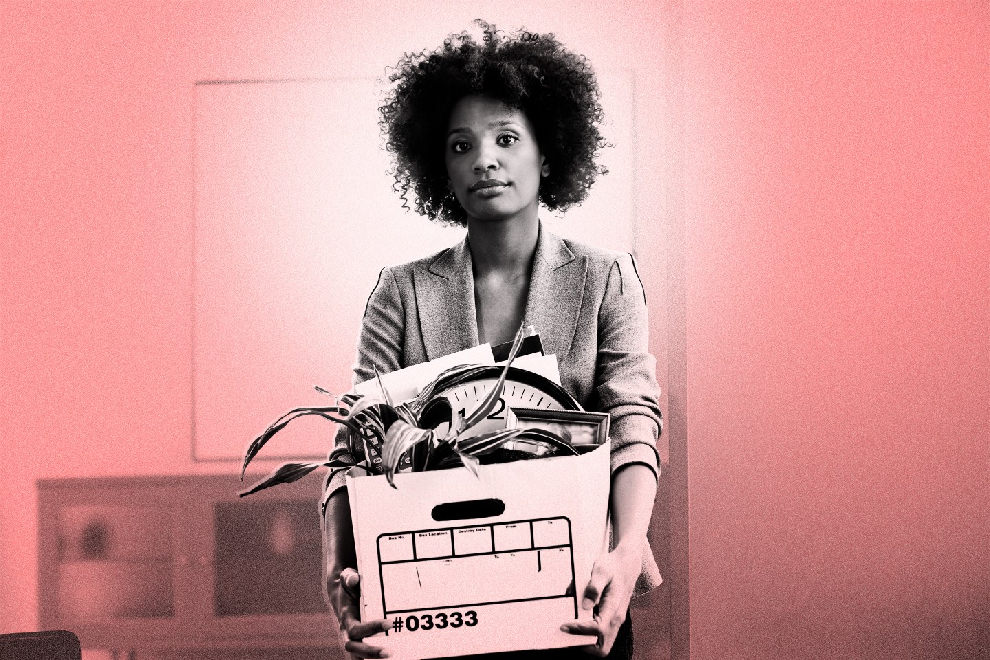 Woman carrying a box of belongings out of an office