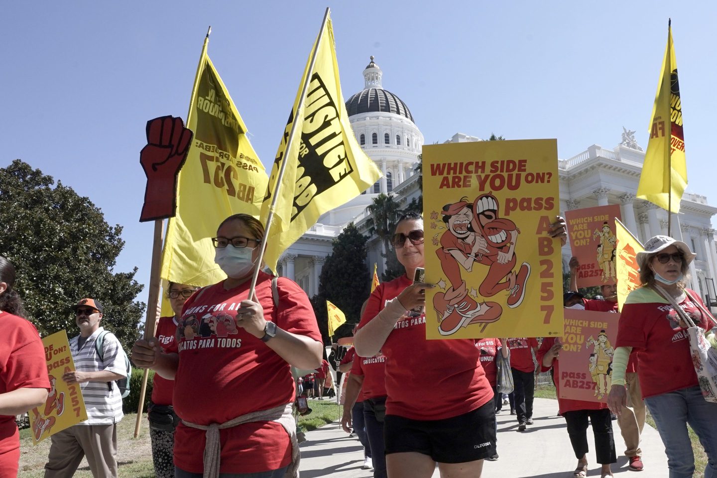 Fast food workers and their supporters march past the state Capitol calling on passage of a bill to provide increased power to fast-food workers, in Sacramento, Calif., on Aug. 16.