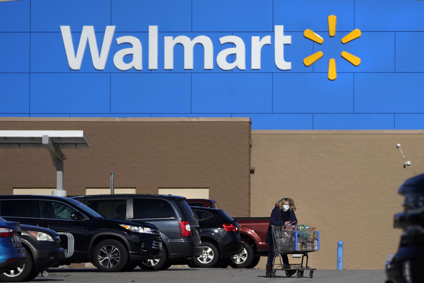 A woman wheels a cart with her purchases out of a Walmart, on Nov. 18, 2020, in Derry, N.H. Walmart, the nation’s largest employer, is expanding its abortion coverage for employees, according to a memo sent to employees Friday, Aug. 19, 2022, after staying mum on the topic for months following the Supreme Court ruling that scrapped a nationwide right to abortion.