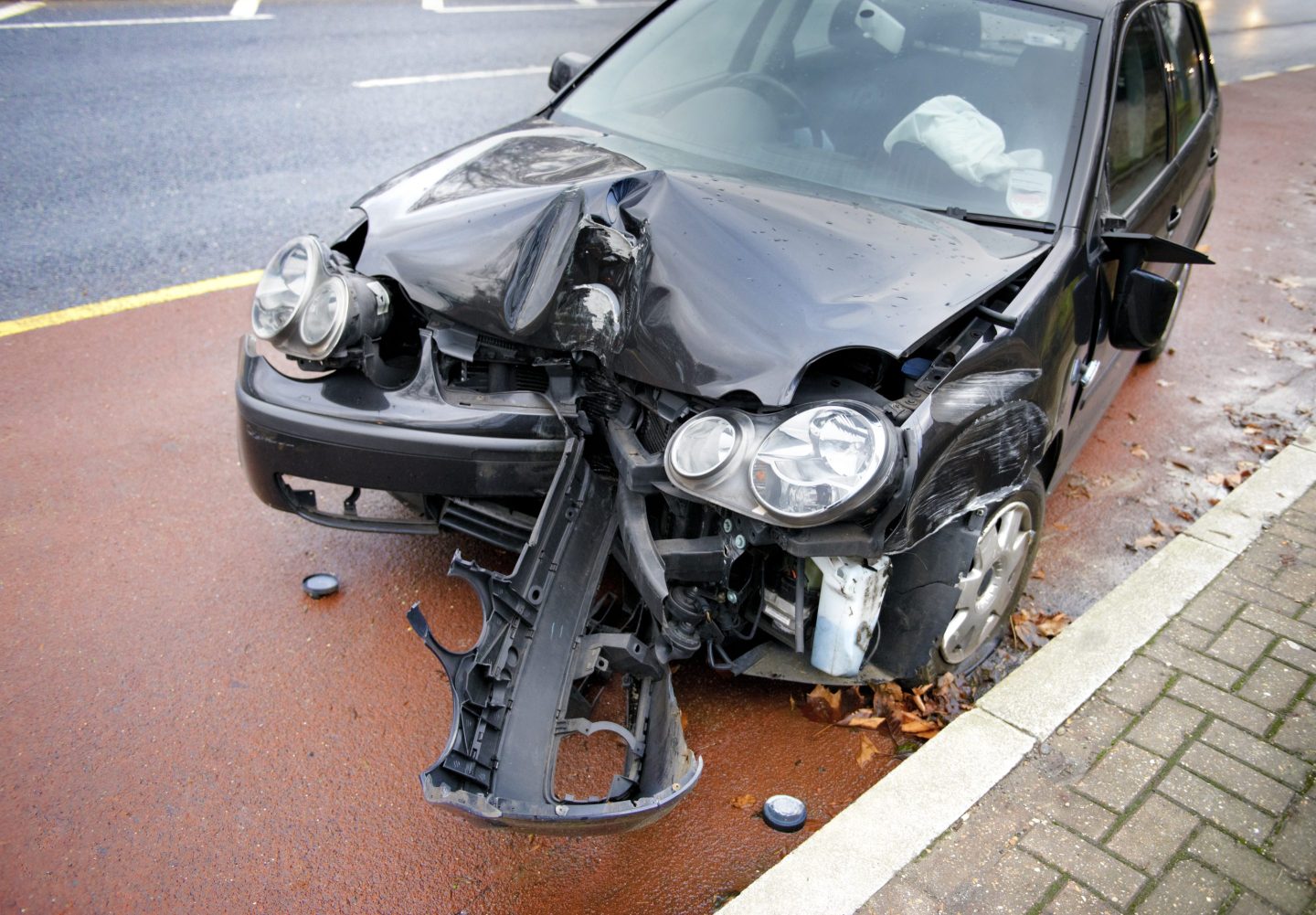 Photo of the badly smashed front end of a black car.