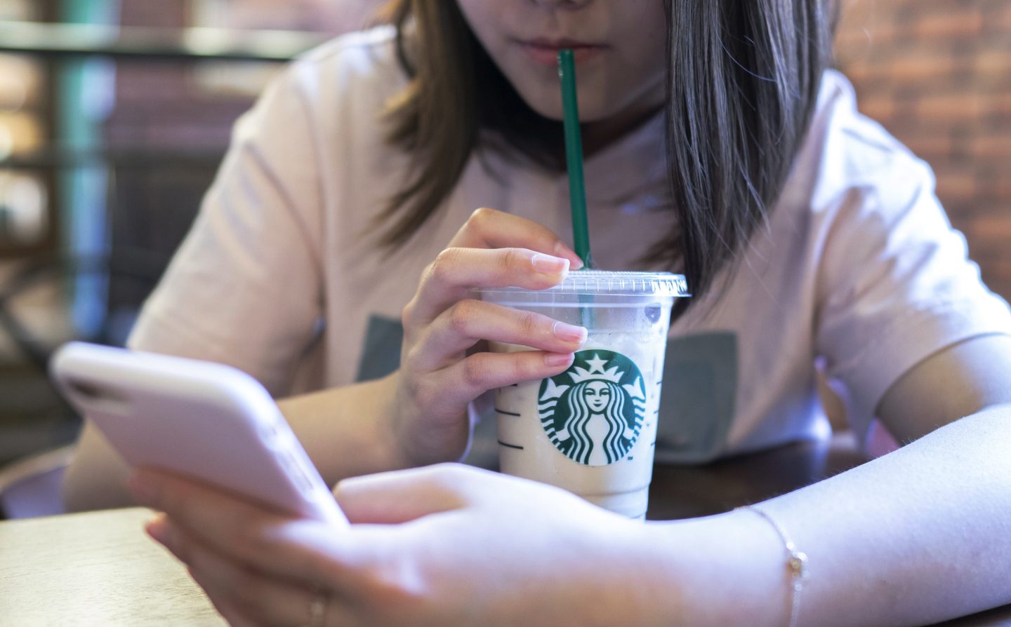 A girl is drinking ice coffee in a Starbucks coffee shop