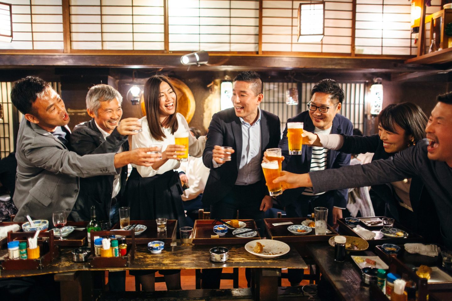 A group of people is seen making a toast in a bar in Japan.