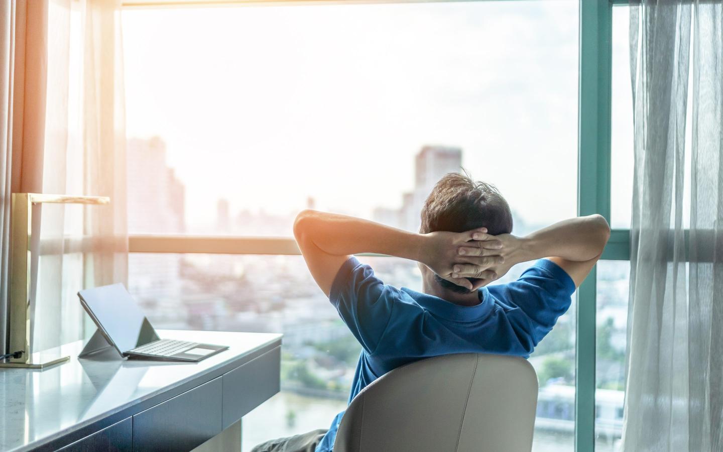 Person leans back in an office chair and daydreams.