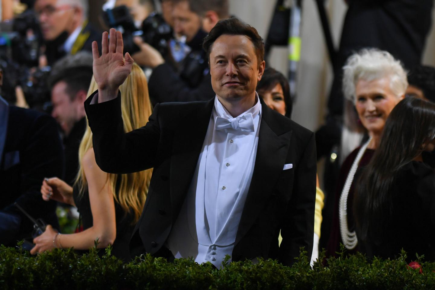 Elon Musk waving to a crowd at the 2022 Met Gala in New York City