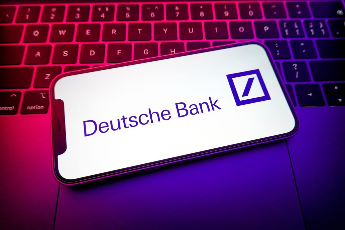 a Deutsche Bank logo is displayed on the screen of a smartphone