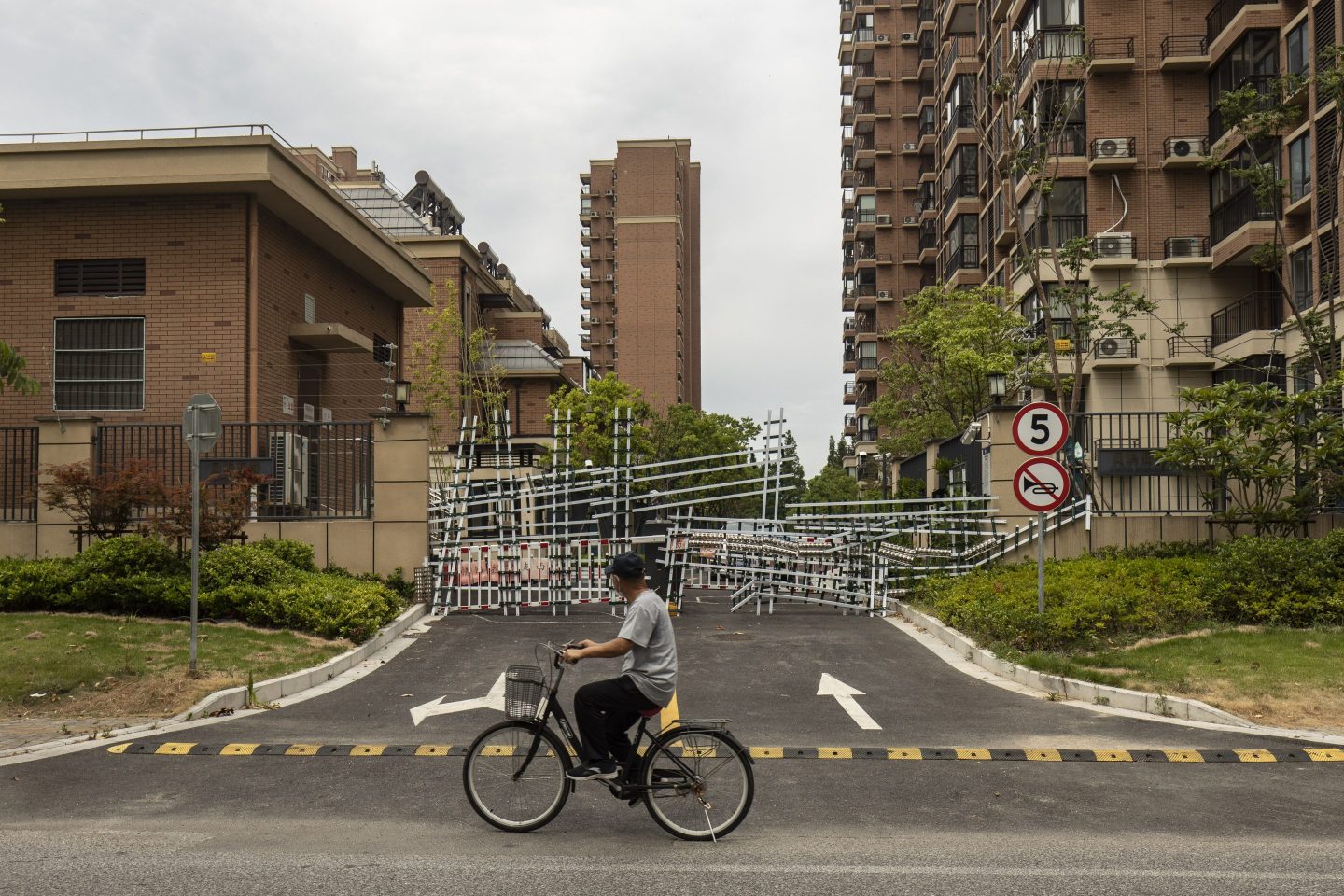 A cyclist rides past a barricaded housing development in Shanghai, China, on July 12, 2022.