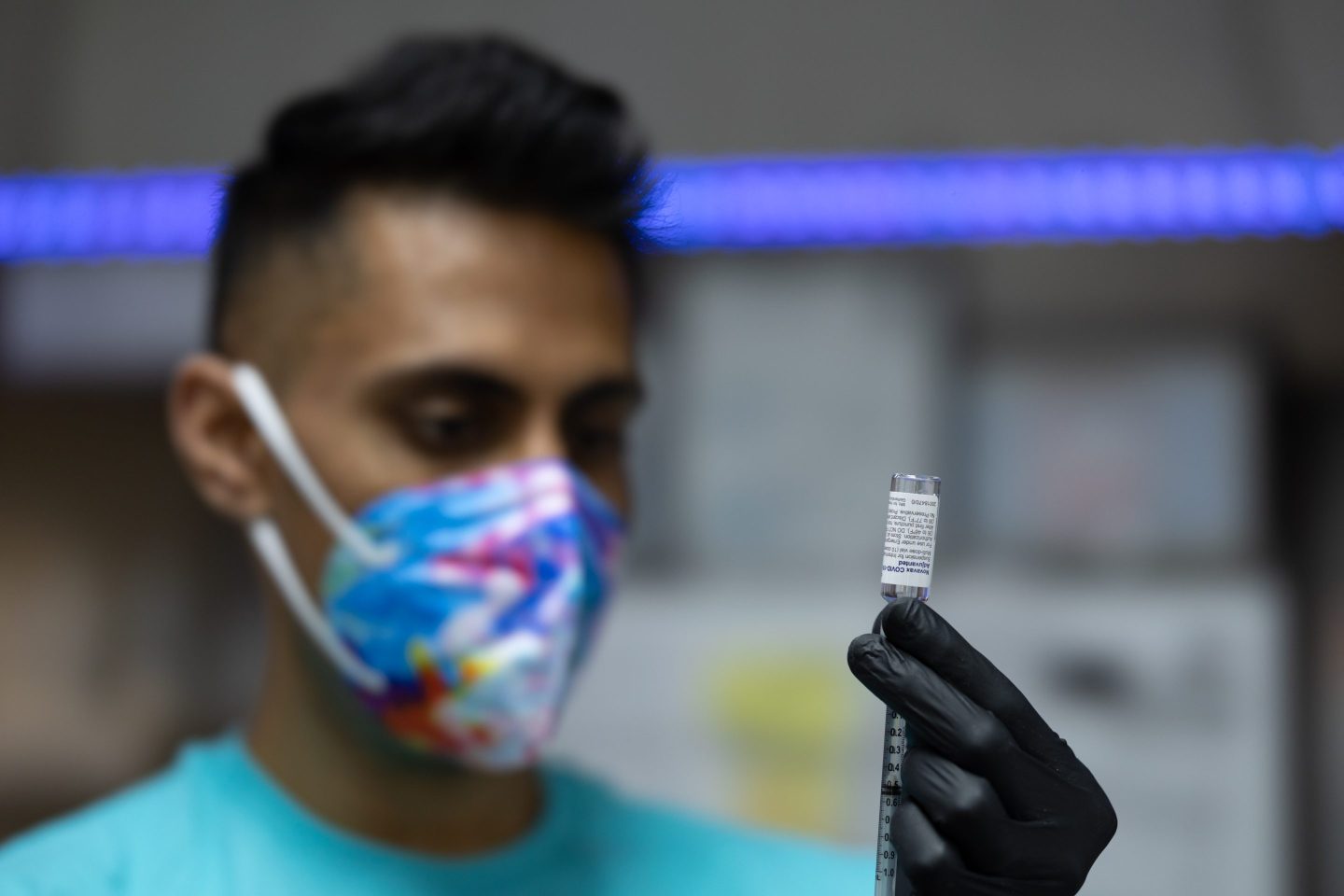A health care worker prepares a dose of the Novavax COVID-19 vaccine at a pharmacy in Schwenksville, Pa., on Aug. 1, 2022.