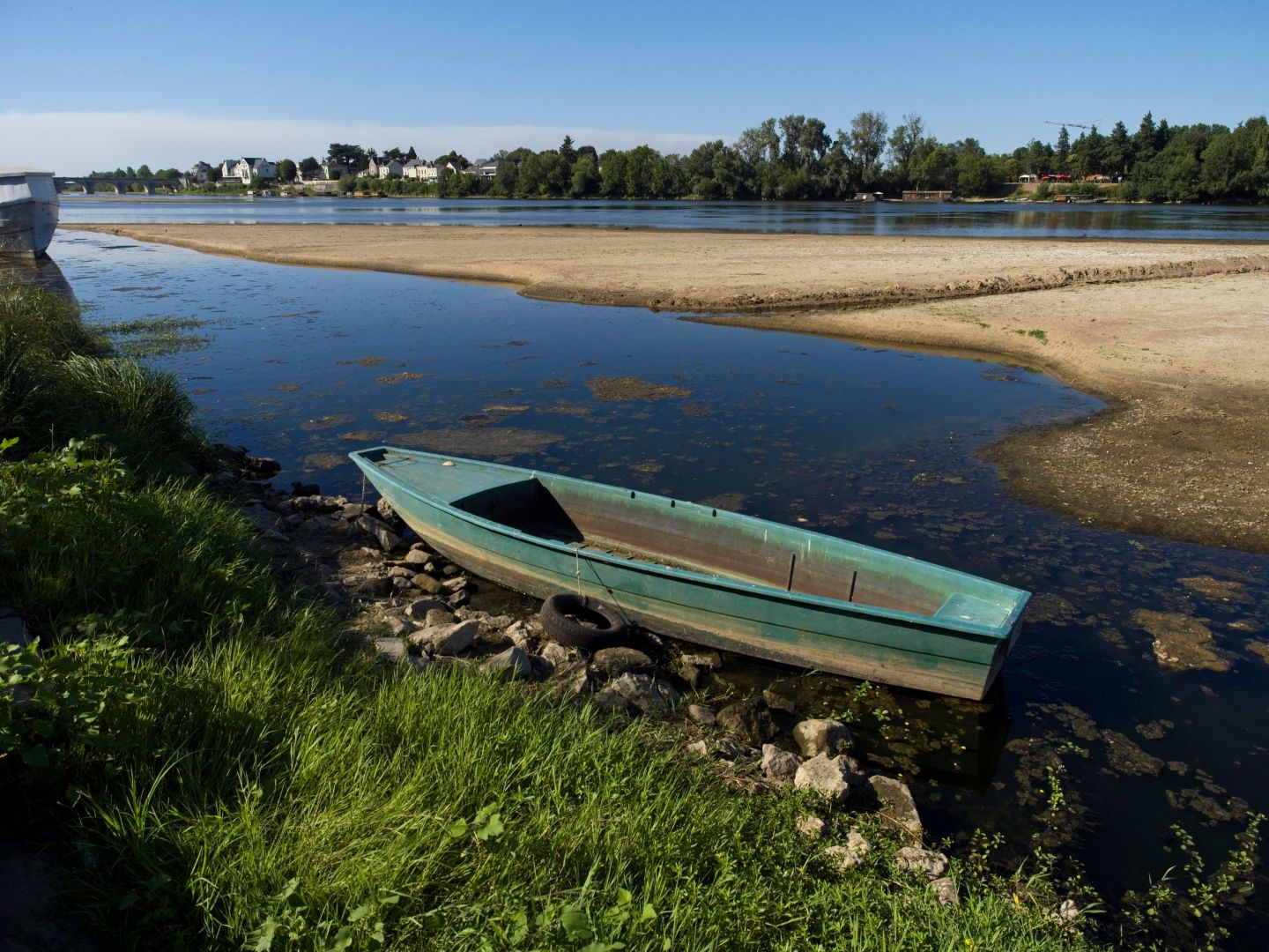 A picture shows a boat and a sand bank showing from the low waters of the Loire River on August 8, 2022 in Saumur, western France.