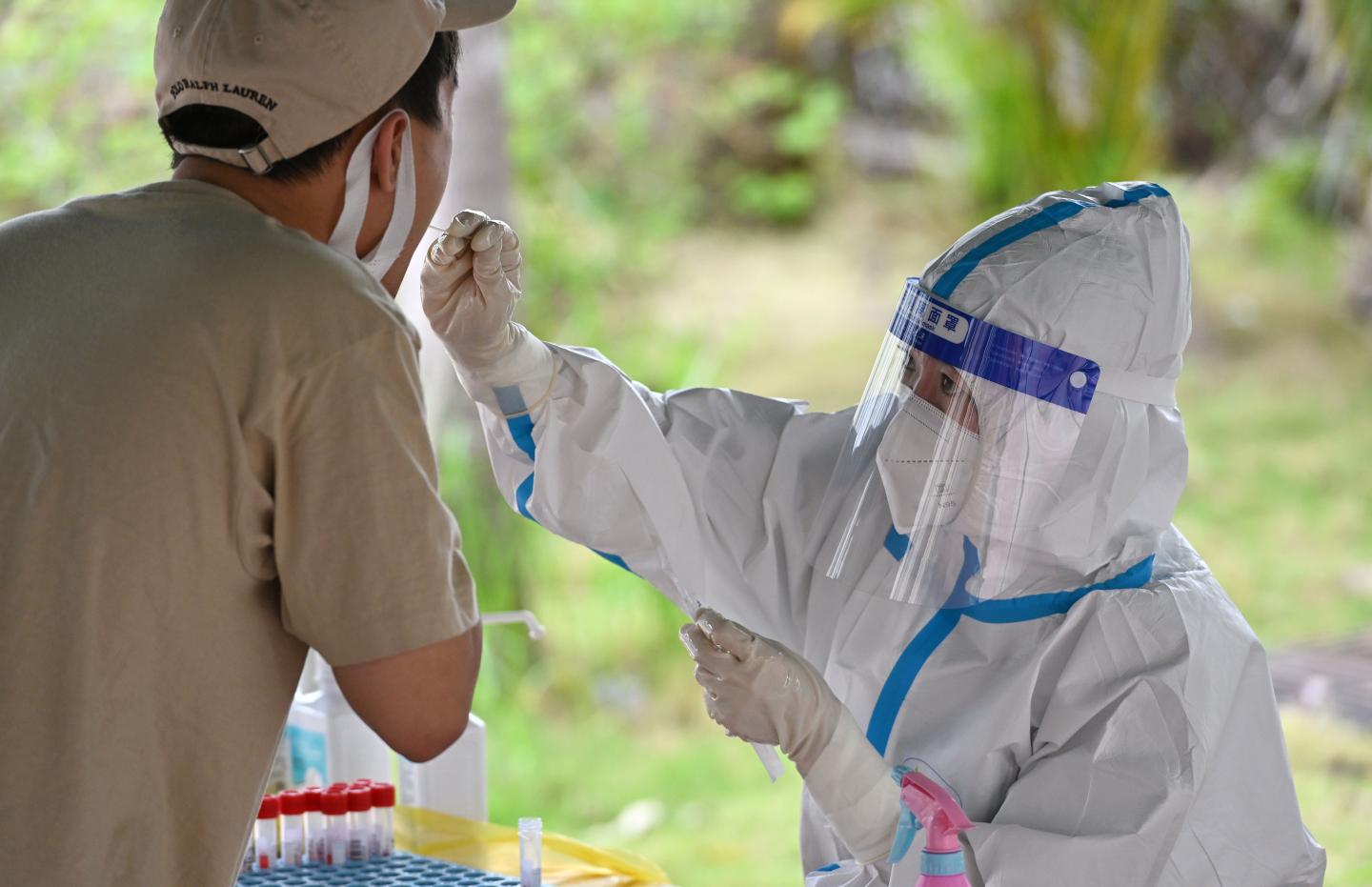 A Chinese healthcare worker administers a COVID test on a patient in Sanya, Hainan province.
