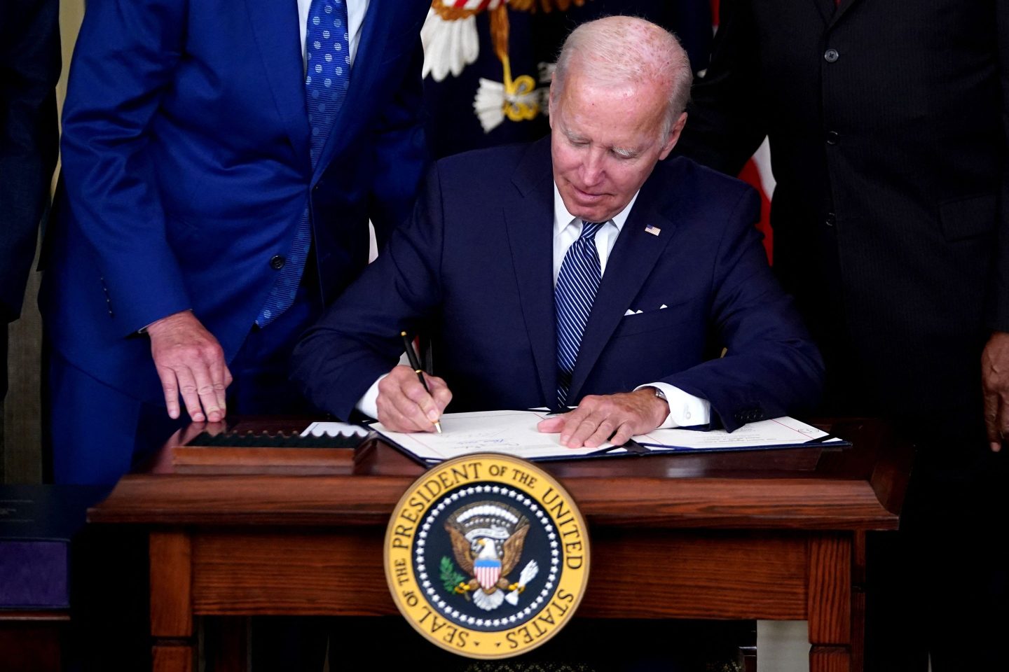 U.S. President Joe Biden signs the Inflation Reduction Act of 2022 on Aug. 16. The law contains key provisions to tackle climate change and high health care costs.