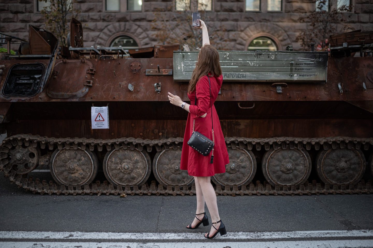 A woman shows a burnt-out Russian military vehicle on display in downtown Kyiv to her relative through a video call on Aug. 22. On Aug. 24, Ukraine celebrates its 1991 declaration of independence from the USSR.