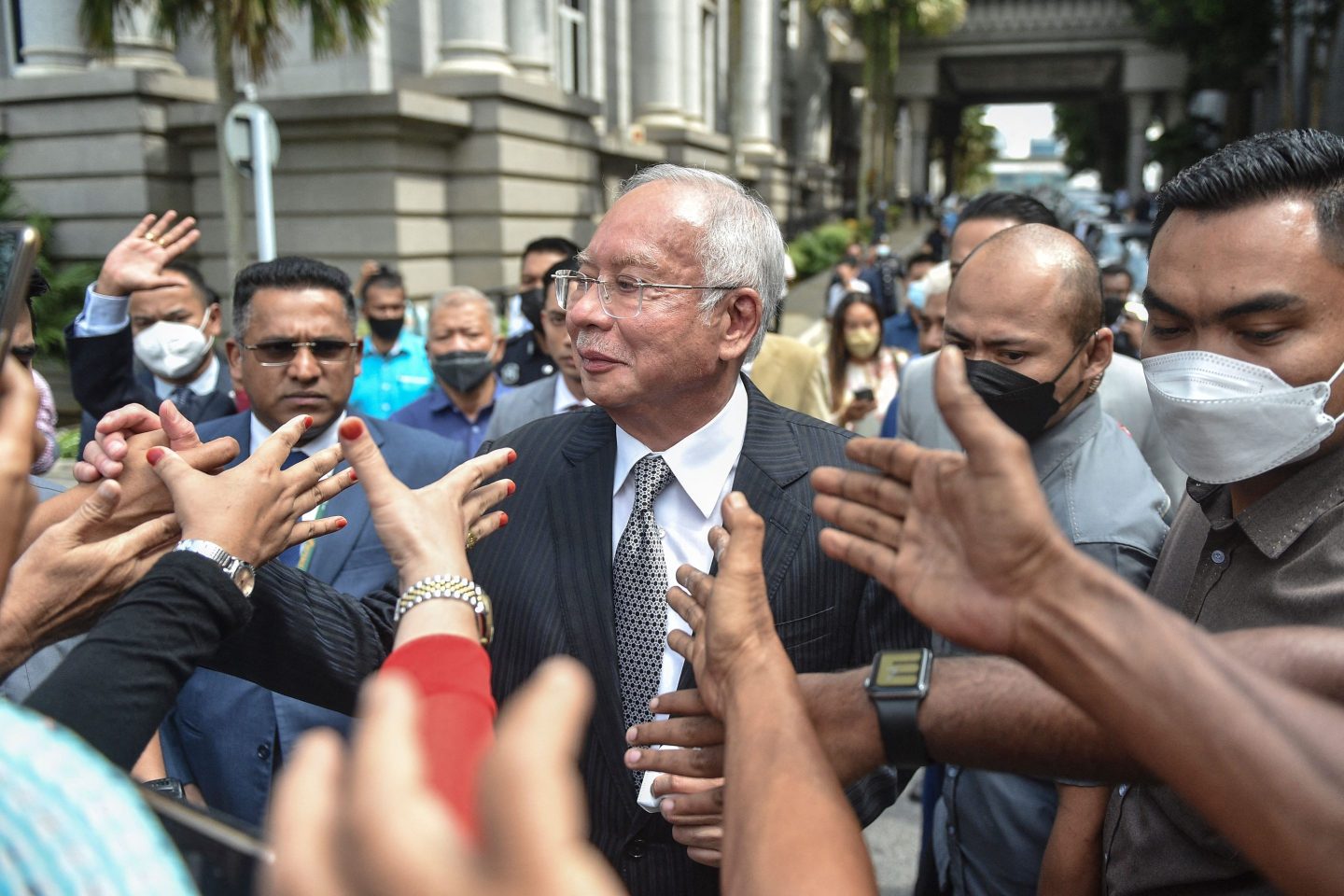 Malaysia's former prime minister Najib Razak greets supporters outside court