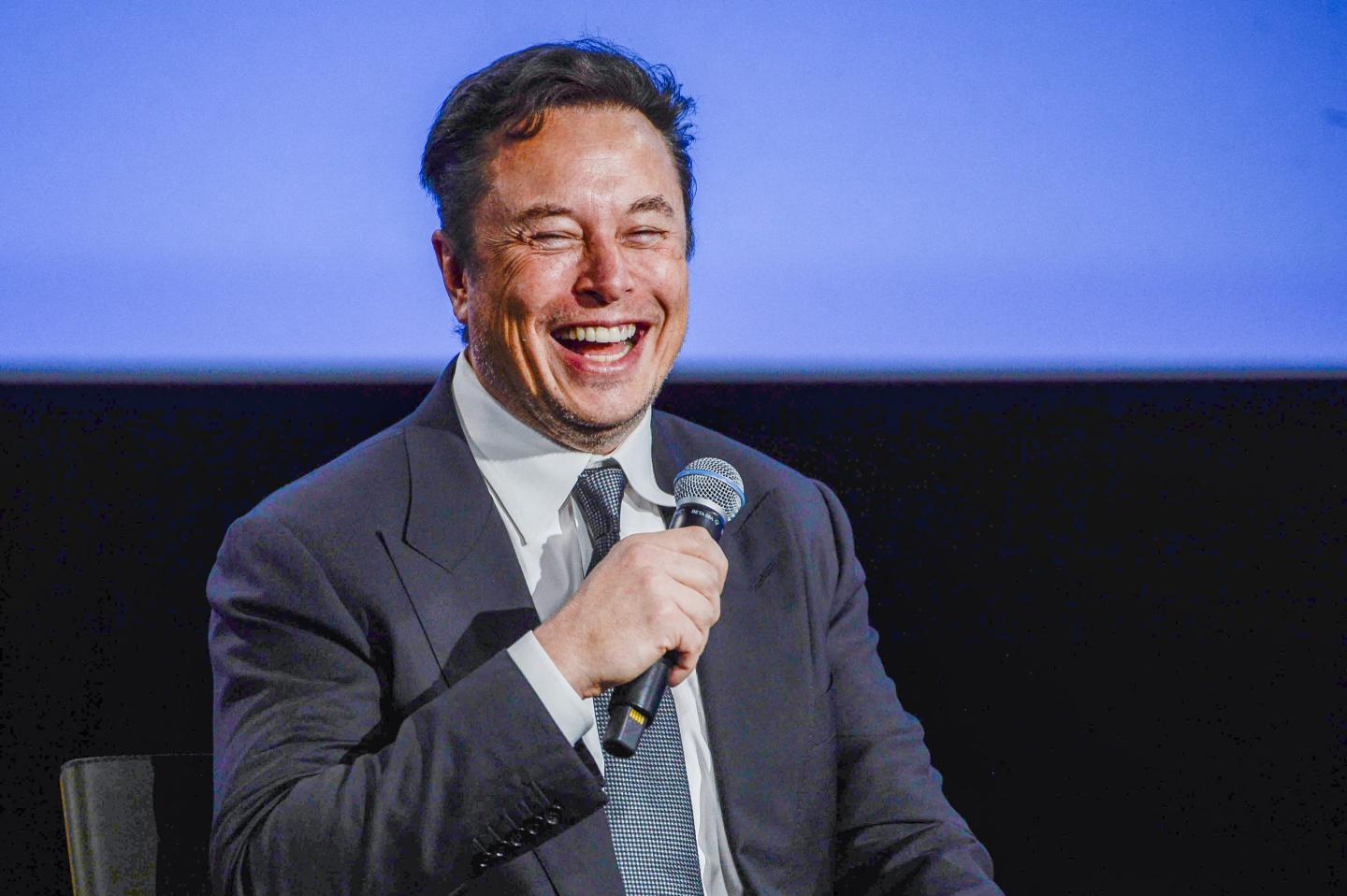 Elon Musk smiles as he addresses guests