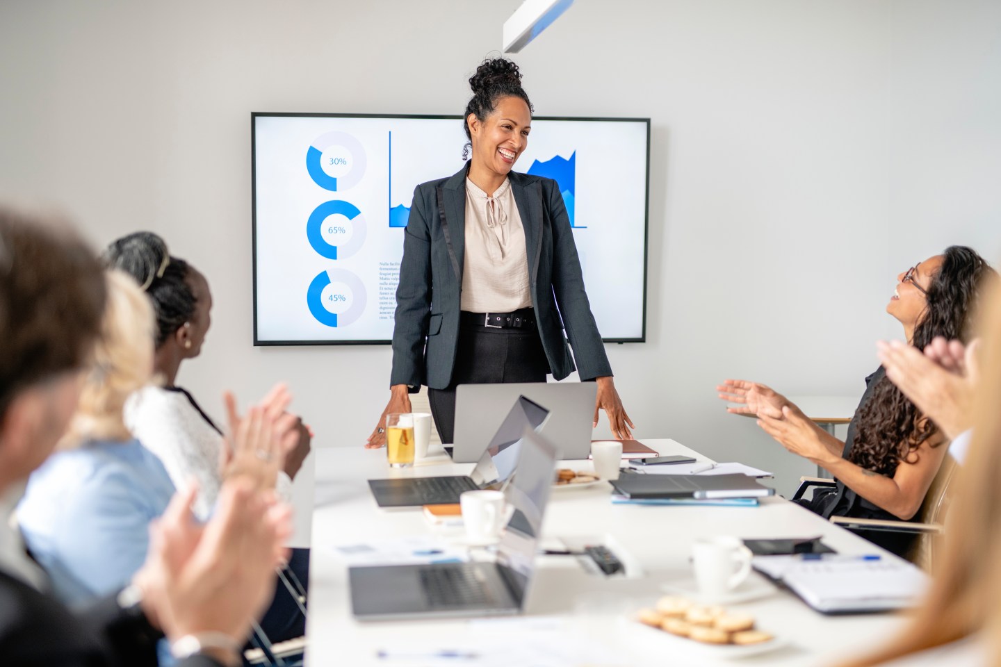 Multi-Ethnic Executive Team Applauding Female leader in Meeting