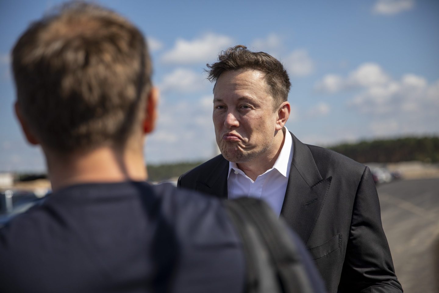 Tesla head Elon Musk talks to one visitor